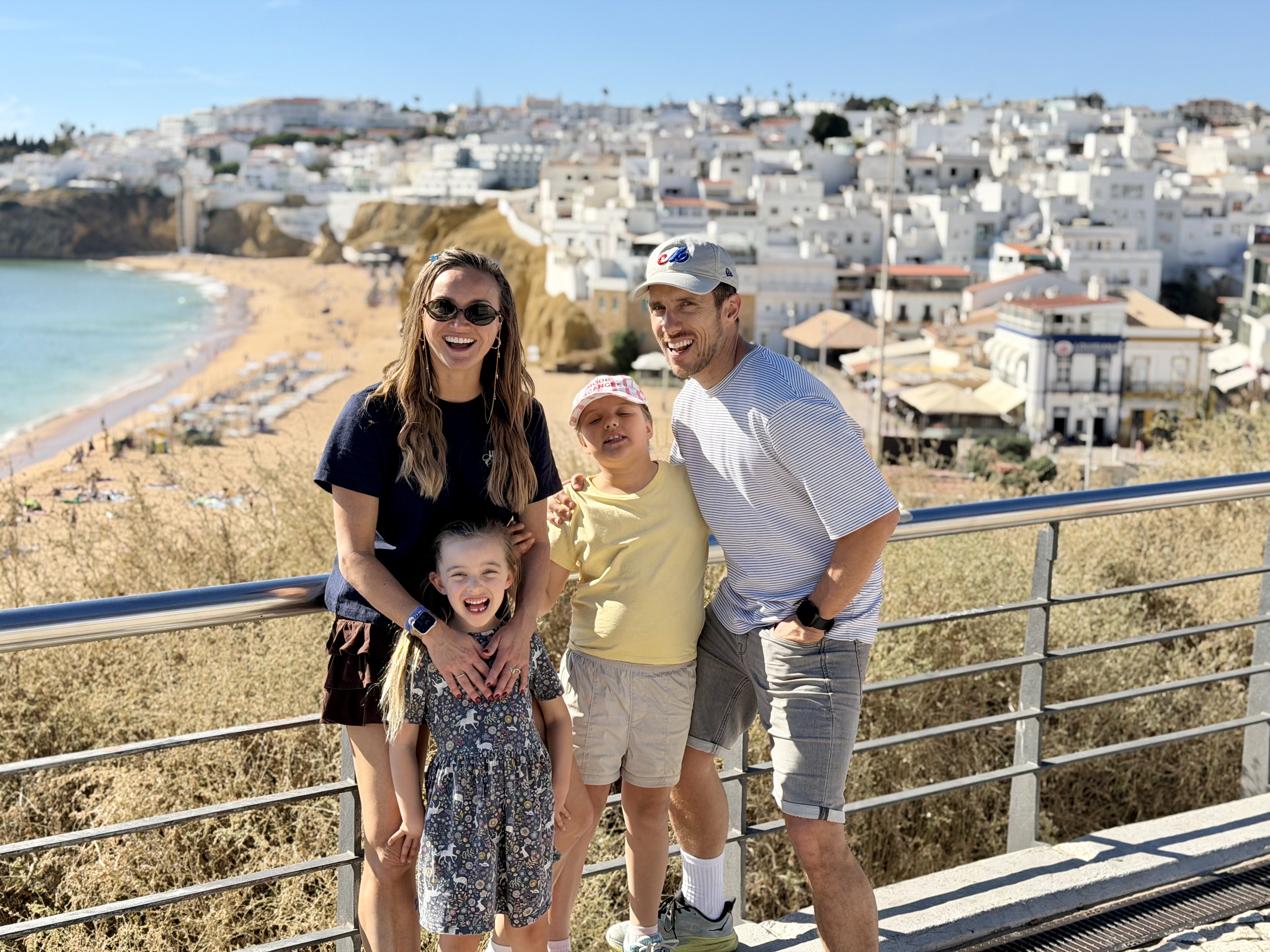 Família sorridente num miradouro sobre a cidade velha de Albufeira